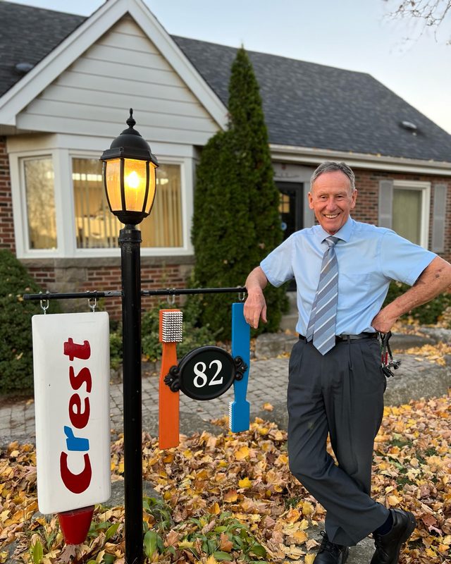 Dr. Rolf Langer, founder of Battlefield Dental, beside the practice's classic toothbrush sign